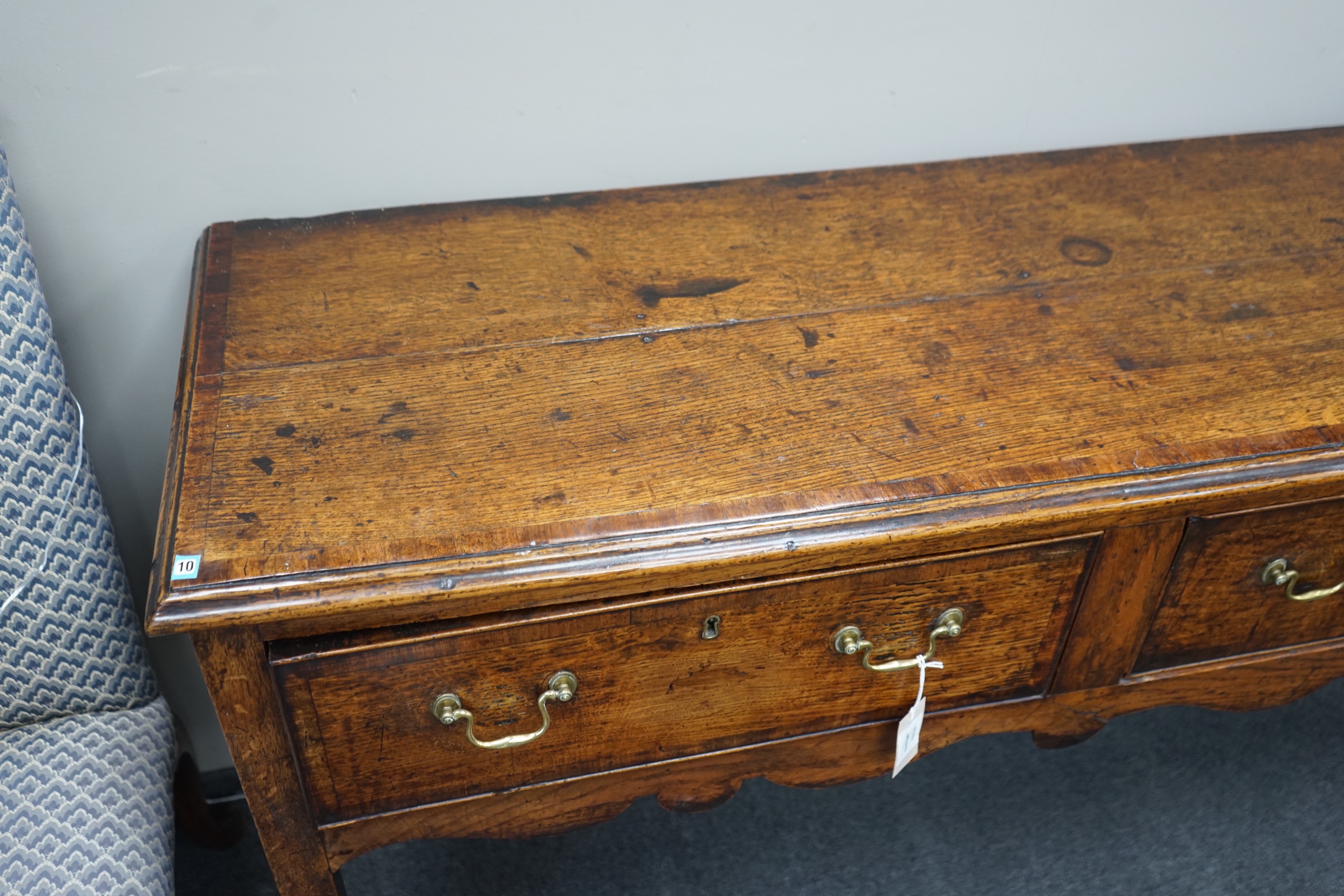 A George III provincial oak and mahogany banded low dresser with three drawers on square tapering legs, width 201cm, depth 46cm, height 83cm